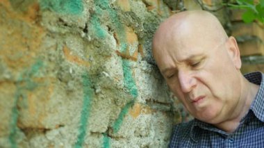 Üzgün ve hayal kırıklığına işadamı düşünceli düşünme bir tuğla duvar yanında