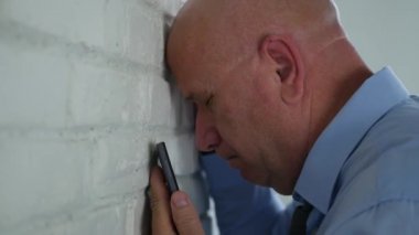 Hayal kırıklığına işadamı kafa ile bir duvar bir cep telefonu metin okuma sonra atıyor.