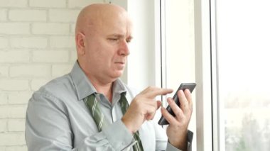 Bir cep telefonu kullanarak Office odada rahat işadamı metin