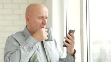 İşadamı cep telefonu e-postaları okumak ve bir fincan kahve içmek