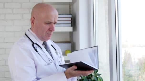 Arzt Krankenhaus Büro Öffnen Medizinische Agenda Blättern Und Lesen — Stockvideo