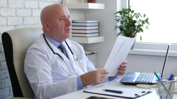 医師のオフィスの仕事机の上文書読み取り契約とする書類に署名を取る — ストック動画