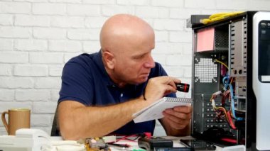 Teknisyen aydınlatma bilgisayarın içinde bir el feneri ile yazmak gündemde