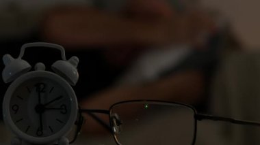 Bulanık görüntü ile bir adam yatakta yastığının düzenleme uyku için hazırlanıyor