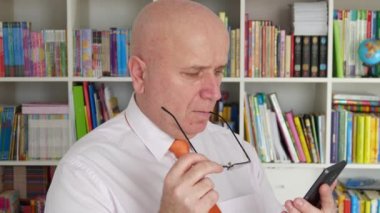 İşadamı okuma mobil metin gözlük el ile el hareketi düşünceli düşünme