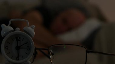 Saat ve gözlük görüntü arka plan bulanık kanepede uyuyan bir adam ile