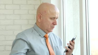 İşadamı kulaklık kullanmak ve Smartphone Online bağlantı erişim App