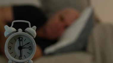 Kötü yorgun adam arka plan bulanık denemek seyir için saat uyumaya