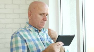Hayal kırıklığına işadamı kullanım elektronik Tablet haberleri okuyun ve endişeli el hareketi