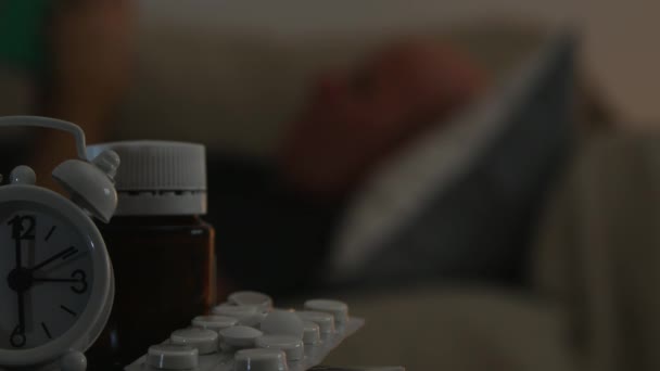 Medical Pills Alarm Clock Foreground Man Sleeping Sofa Blur — Stock Video