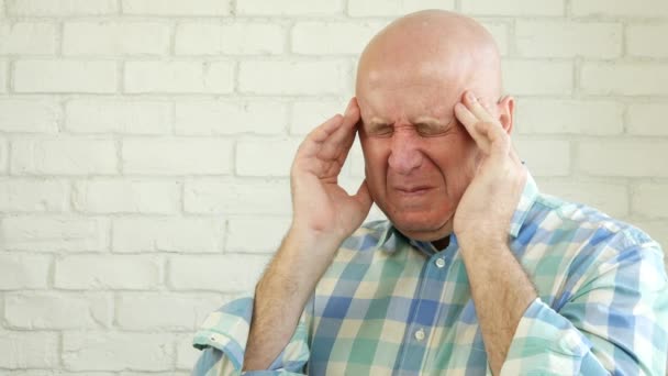背景の白いレンガの壁と大きな痛みを伴う頭痛に苦しんでいる人 — ストック動画