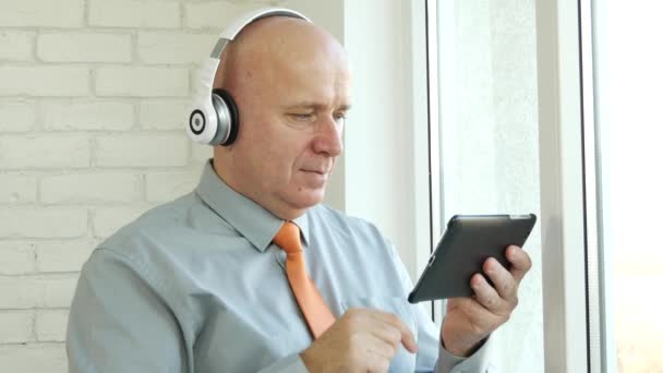 Man Thuis Luisteren Muziek Met Draadloze Hoofdtelefoons Tablet Muziek App — Stockvideo