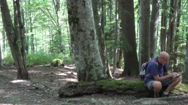 Pan görünümü ile yorgun turist görüntü dokunmatik Tablet bir dağ gezisi kullanma