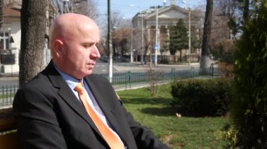 El izle kontrol geç bir toplantı bekleyen bir bankta oturan işadamı