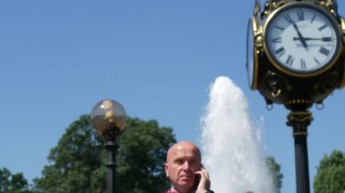 Bir tarih bekliyor el konuşmasında cep için çiçek bir grup ile takım elbise giyen adam