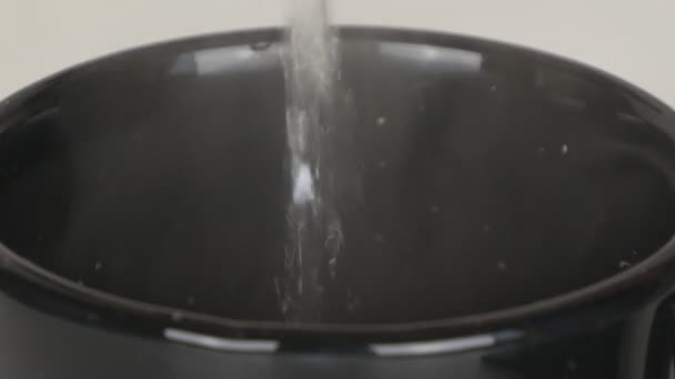 Fermer avec une tasse noire remplie d'eau bouillie faisant un cappuccino chaud 