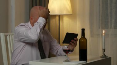 Gergin mimik tablo okuma elektronik Tablet kötü haber üzerinde oturan adam