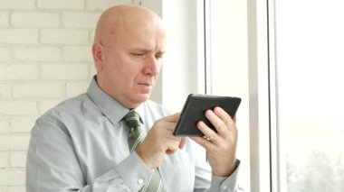 İşadamı kullanım elektronik Tablet iyi haberleri okuyun ve yapmak zafer el hareketleri