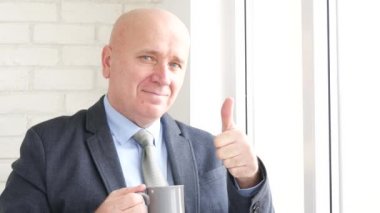 Mutlu işadamının Yaşasın çay içmek ve iyi iş el hareketleri yapmak gülümsemek