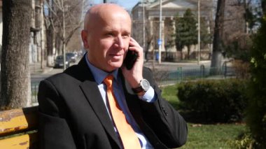 Park hevesli işadamı cep ve yapmak zafer el hareketleri için konuşun