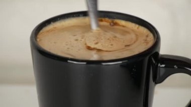 Renkli aromalı ve lezzetli kahve köpüğü kaşıkla karışık ile sıcak Kupası