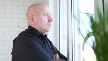 İşadamı ciddi kalmak ve dalgın ve pencerenin önünde endişeli düşünüyorum