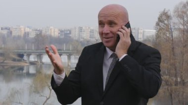 Ağır çekim mutlu işadamı konuşup cep olun zafer el hareketleri