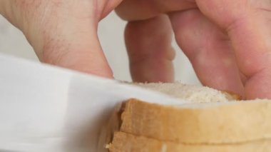 Dilim ekmek ve jambon ile lezzetli sandviç adam ellerini yukarıya kapatmak