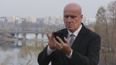 Yavaş hareket ciddi işadamı konuşup mobil ofis dışında el hareketi