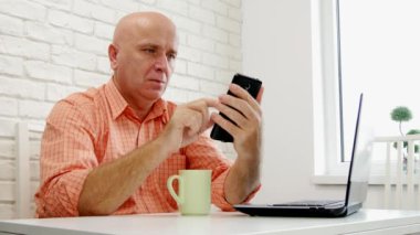 İşadamı evde Office kullanım cep telefonu Internet bağlantısı e-postaları okumak.