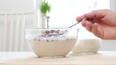 Bir kase süt ve tatlı tahıllar ile yakın görüntü bir kaşık ile karışık