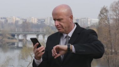 Ağır çekim ile cep mesaj ve kol saati saat bakarak işadamı