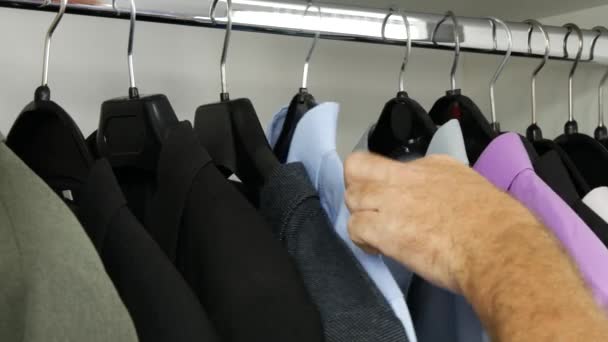 Mann sucht in Kleiderschrank wählen Sie ein blaues Hemd (ultra high definition, ultrahd, ultra hd, uhd, 4k, 3840x2160) — Stockvideo