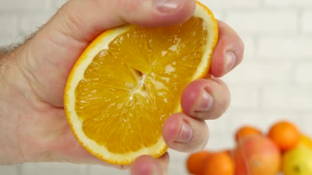 Close Up Man Mão espremendo uma fruta laranja doce e suculenta (Ultra alta definição, UltraHD, Ultra HD, UHD, 4K, 3840x2160 ) — Vídeo de Stock