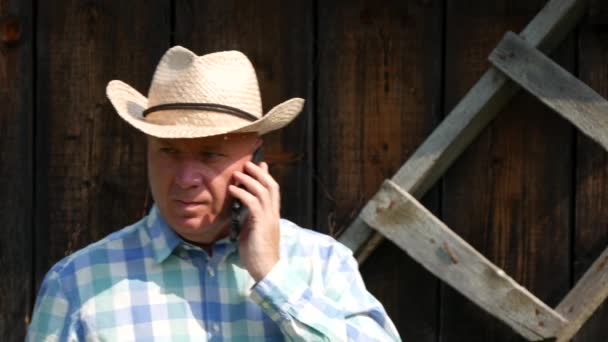 Farmář na sobě kovbojský klobouk v chovné mluví do mobilu a ukázal (Ultra High Definition, Ultrahd, Ultra Hd, Uhd, 4k, 3840 x 2160) — Stock video