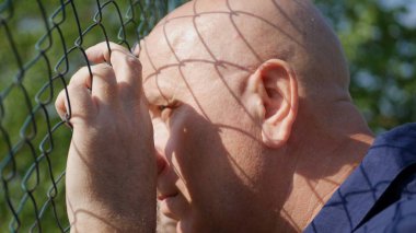 Umutsuz adam metalik bir çit üzülmüş