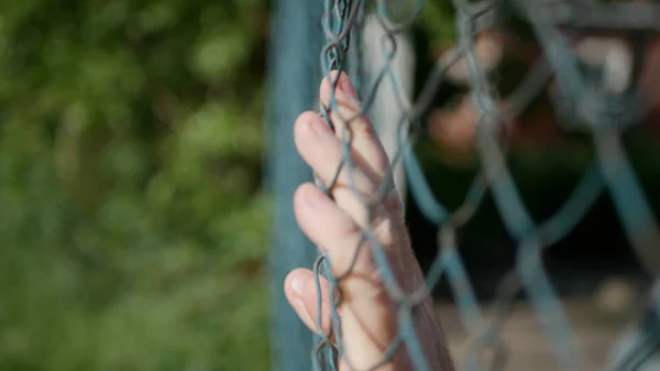 Mannen händerna bild glidande på ett metalliskt staket — Stockfoto