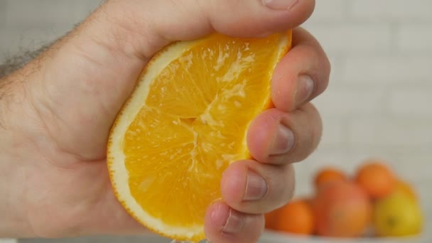 Cerrar la mano apretando una fruta naranja jugosa — Vídeos de Stock