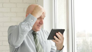 İşadamı kullanım elektronik Tablet iyi haberleri okuyun ve yapmak zafer el hareketleri