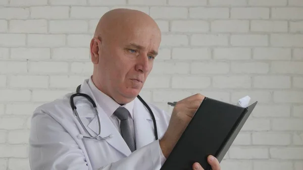 Уверенный доктор делает заметки, используя медицинскую повестку дня — стоковое фото