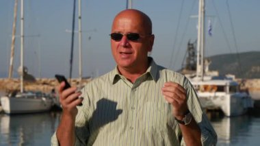 Adam güneş gözlüğü ve hücre el Turizm hakkında konuşmak