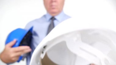 Bir meslektaşım bir kask için kafa koruma sunan Closeup görünümü işadamı