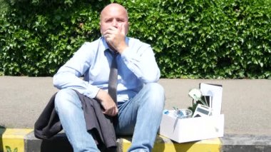 Sorunlu kişi konaklama bir kutusunun yanındaki kaldırım sınırında hayal kırıklığına ateş