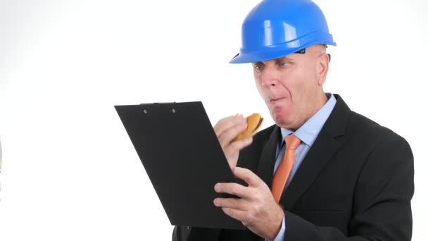 エンジニアは 休憩を取るおいしいサンドイッチやクリップボードからの読み取りを食べる — ストック動画