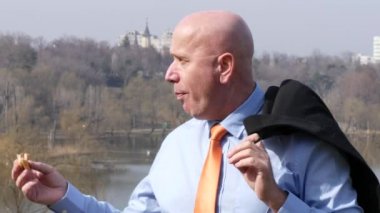 Onun öğle tatilinde Park'ta yürüyordunuz Office dışında sandviç yeme işadamı