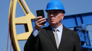 Yağda çalışma işadamı ayıklama sanayi cevap ve cep telefonu için konuşuyor