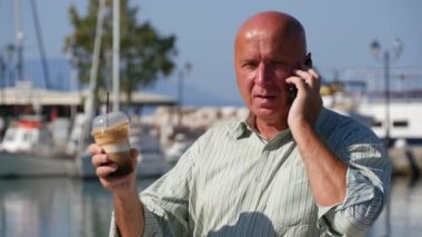 Cep telefonunuza konuşan işadamı ve buzlu kahve içme sıcak bir günde el hareketi