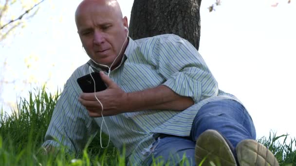 Homem Relaxante Parque Fique Deitado Ouça Música Usando Aplicativo Celular — Vídeo de Stock