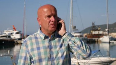 Ciddi bir bağlantı noktası açıklayan ve Gesturing cep telefonu için konuşan işadamı