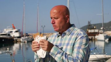 Aç adam turist işinde çalışan şehir limanda kalmak ve lezzetli bir pasta yemek